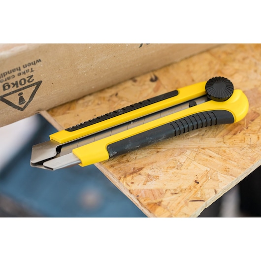 STANLEY 0-10-425 utility knife with yellow and black handle, photography on wooden surface.