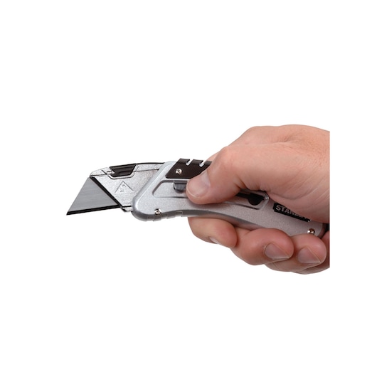 Photo of STANLEY 0-10-810 utility knife with silver body, held in a hand, side angle on white background.