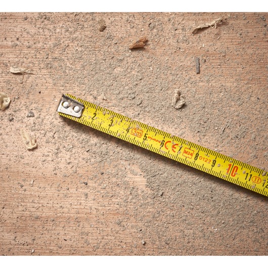 STANLEY 0-30-687 yellow tape measure on dusty brown surface, close-up angle.