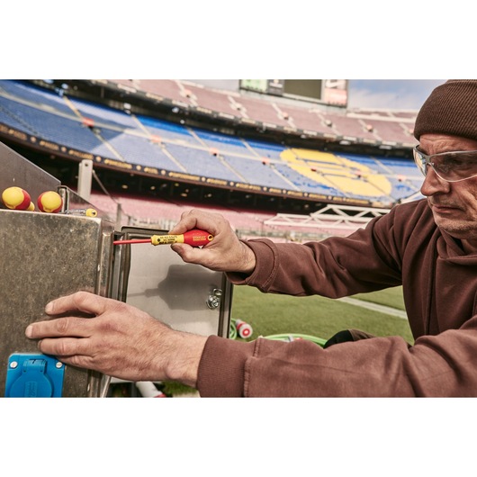 Photo of STANLEY 0-65-443 insulated screwdriver in use on metal electrical box at stadium.