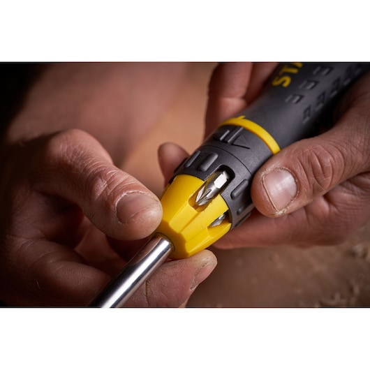 Close-up photo of STANLEY 0-68-010 multi-bit screwdriver handle showing bit storage and yellow grip.