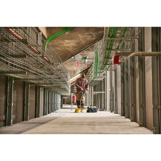 STANLEY 0-84-004 electrician working with tools in a large industrial facility, seen from a low angle.