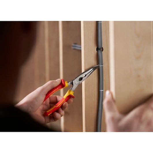 Photo of STANLEY 0-84-008 insulated long nose pliers securing wire to wooden frame.