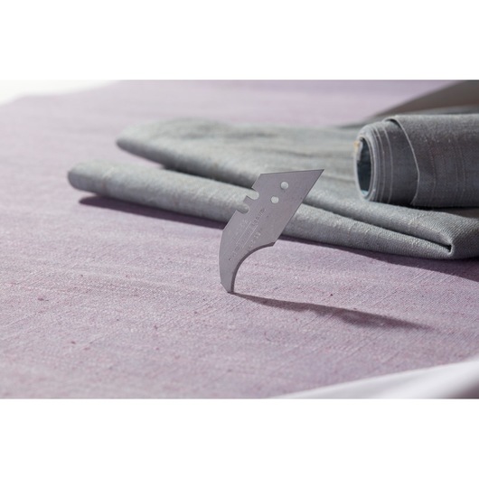 STANLEY 1-11-952 curved carpet blade standing upright on fabric, close-up side angle photography.