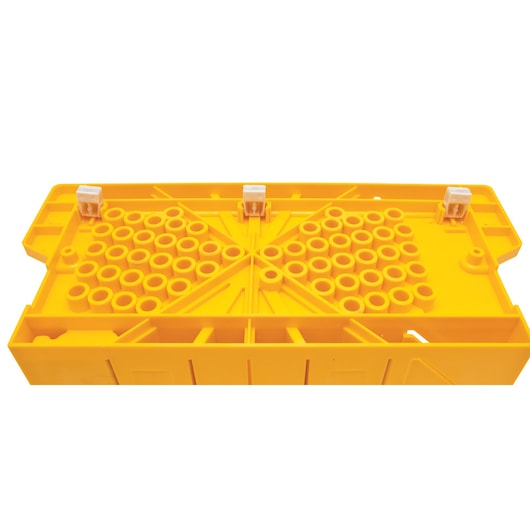 Yellow STANLEY plastic mitre box with multiple circular holes and three white clamps on top.