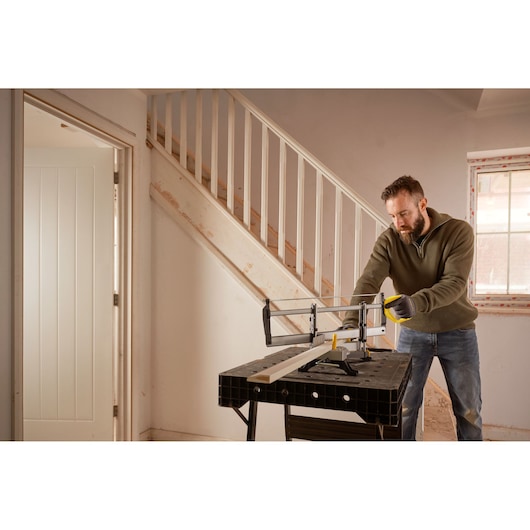STANLEY 1-20-800 hand saw used on a workbench indoors by a person cutting wood near stairs.