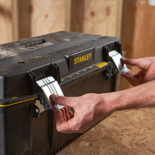 Photo of STANLEY 1-93-935 toolbox with metal latches being opened, black and yellow design.