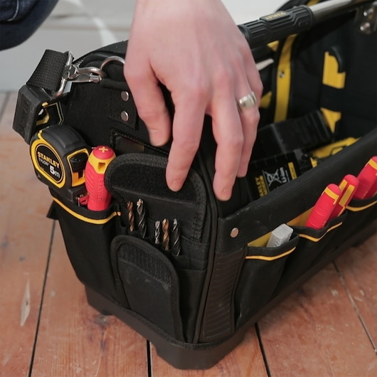 STANLEY 1-93-951 photography of a black tool bag with hand, tape measure, screwdrivers, and drill bits.