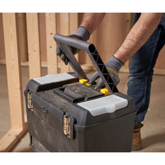 STANLEY 1-93-968 tool box with handle, black plastic, photographed in workshop setting.