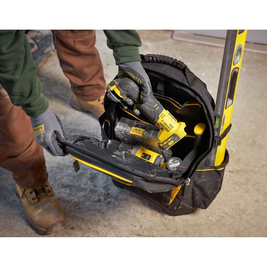 STANLEY 1-95-611 tool bag with tools, including level and drill, photographed from above in workshop setting.