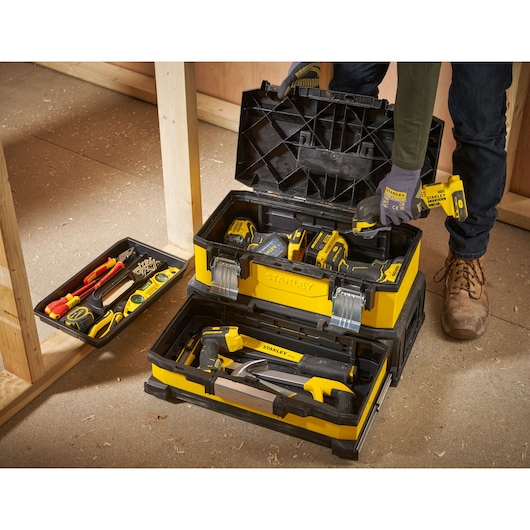 STANLEY 1-95-829 toolbox filled with assorted tools, open on a construction site, front angle view.