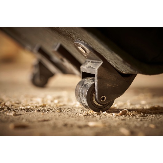 STANLEY 1-97-515 toolbox wheel close-up photography, black plastic caster on rough surface.