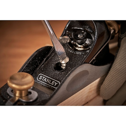 STANLEY 12-020 hand plane close-up, screwdriver adjusting blade, woodworking tool in use.