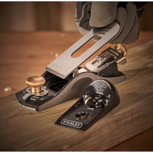 STANLEY 12-020 hand planer close-up on wooden surface, showing metal and brass parts, photography angle.