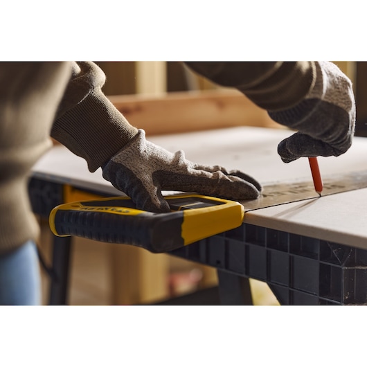 Photo of STANLEY 2-15-244 hand saw on workbench, person wearing gloves marking wood.