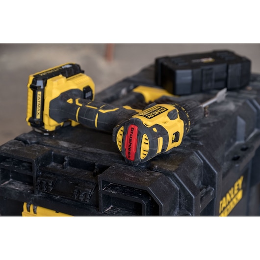 STANLEY FMC627D2 brushless cordless drill in yellow and black resting on a rugged toolbox, side angle.