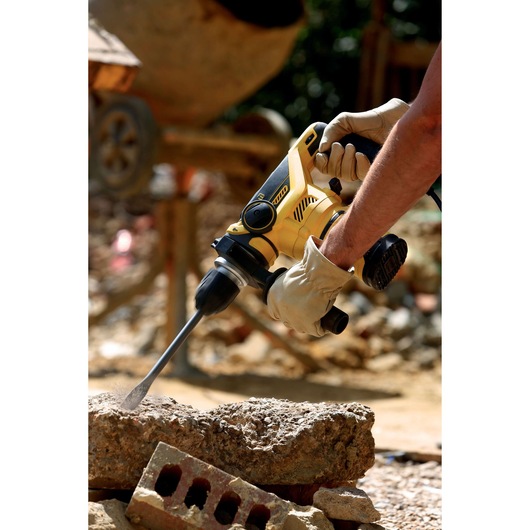 STANLEY FME1250K rotary hammer drill in use on concrete at construction site, close-up photography.