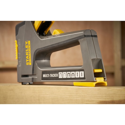 STANLEY FMHT6-70868 multi-tacker stapler side view, black and yellow, on wooden surface.