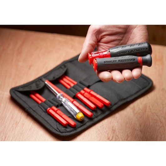STANLEY FMHT66426-0 screwdriver set with black and red handles and multiple bits in a black fabric case, close-up.