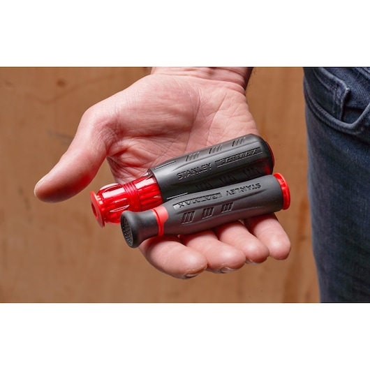 STANLEY FMHT66426-0 compact multi-bit screwdriver with black and red handle held in hand.