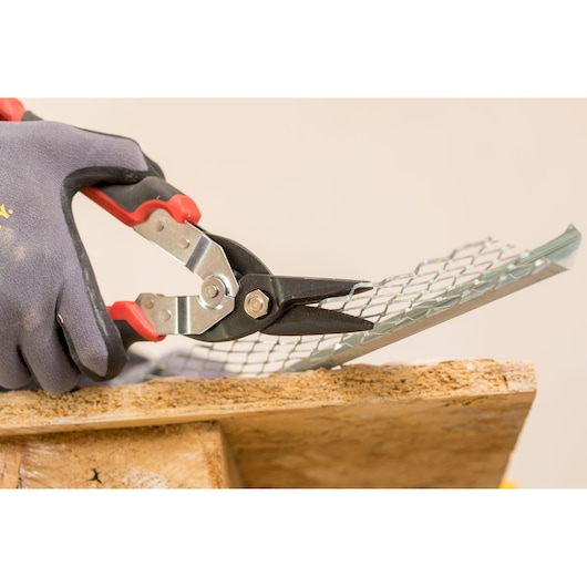 STANLEY FMHT73755 aviation snips cutting metal mesh, close-up photo with gloved hand.