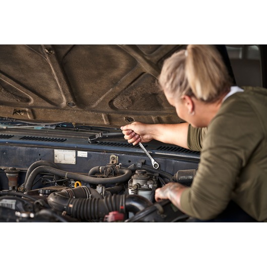 Person using STANLEY FATMAX Reversible Ratcheting Wrench on car engine, STANLEY FMMT82848-0, tool in automotive repair.