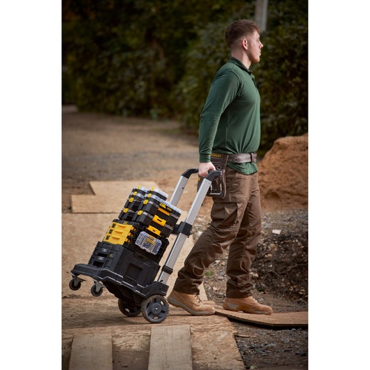 STANLEY FMMT98101-0 stackable toolboxes on trolley cart, outdoor worksite, side view.