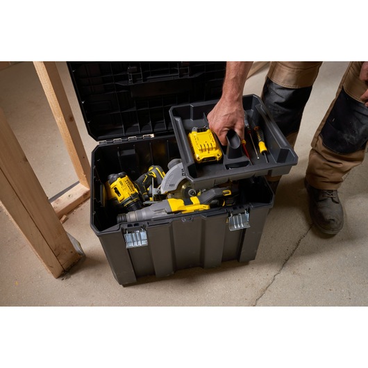STANLEY FMST1-75753 toolbox with removable tray, shown open filled with power tools on a workshop floor.