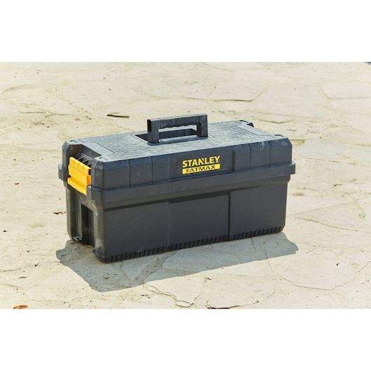 STANLEY FMST81083-1 toolbox, black plastic with yellow latches, outdoor angle photography.
