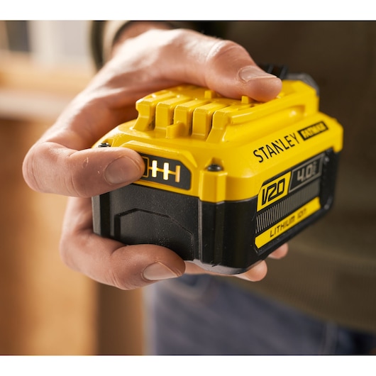 Photo of STANLEY SFMCB204 V20 4.0Ah lithium ion battery held in hand, close-up view.