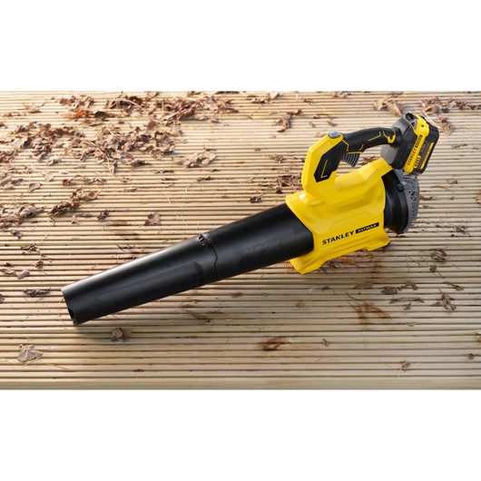 STANLEY SFMCBL730M1 cordless leaf blower on a wooden deck, yellow and black design, lateral view.