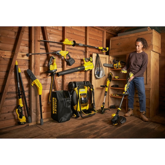 STANLEY SFMCBL7M1 photography of yellow and black outdoor power tools displayed in a wooden shed.
