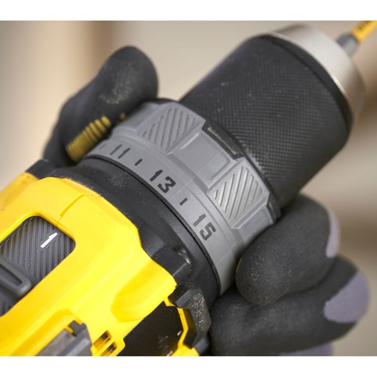STANLEY SFMCD725B drill close-up showing torque settings, yellow and black design, gloved hand holding.