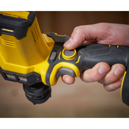 STANLEY SFMCE210B hammer drill close-up, hand gripping black and yellow handle and trigger.