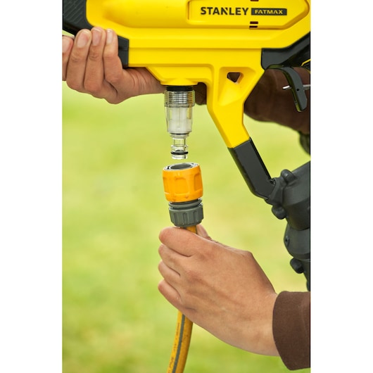 STANLEY SFMCPC93M1 power tool hose connection close-up with hands assembling, outdoor setting.