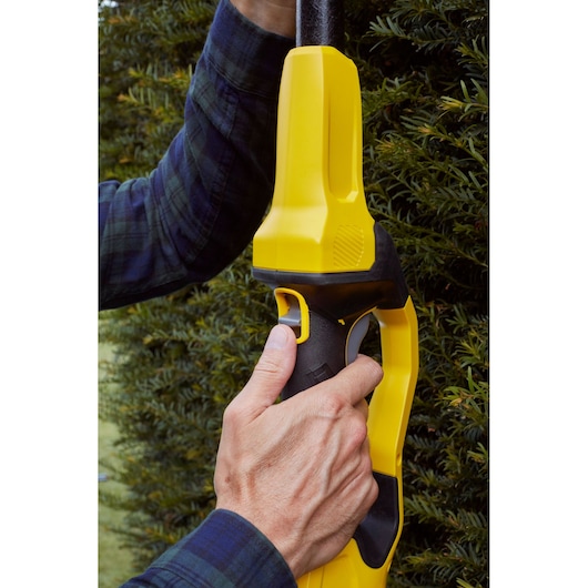 Photo of a STANLEY SFMCPH845B pole hedge trimmer handle being held during outdoor use.