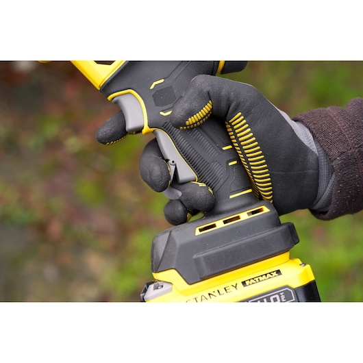 STANLEY SFMCPP32M1 cordless tool handle close-up, yellow and black plastic, gloved hand holding.