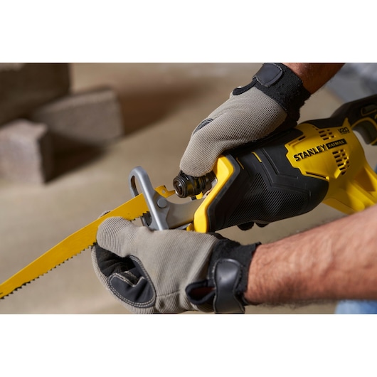 STANLEY SFMCS300B reciprocating saw held by gloved hands, yellow and black close-up side view.