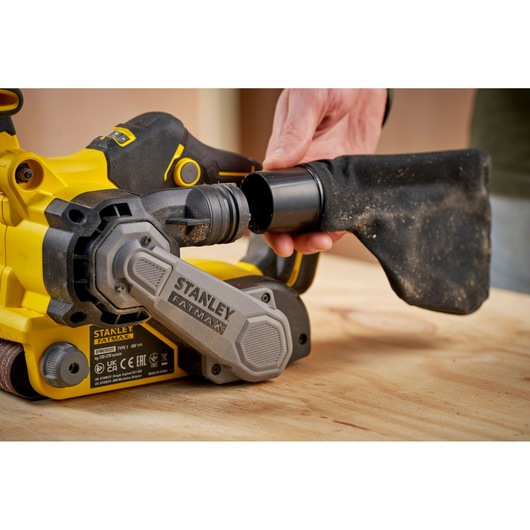 STANLEY SFMCW223B-XJ belt sander side view with dust bag being attached, yellow and black finish.