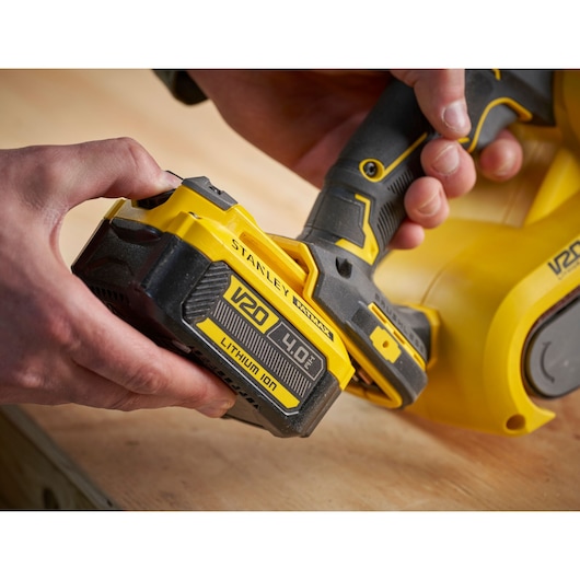 Stanley SFMCW223B-XJ V20 cordless tool with 4.0Ah lithium-ion battery, close-up angle on wooden surface.