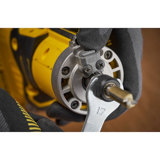 STANLEY SFMCW400B photography of a yellow power tool with a wrench adjusting the front part.