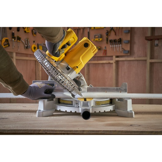 STANLEY SM1650 miter saw being used to cut metal, shown from side angle in workshop.
