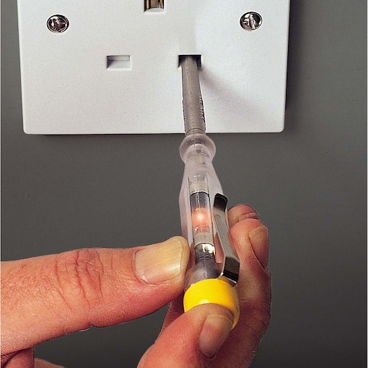 STANLEY STHT0-66121 voltage tester screwdriver in use on electrical outlet, close-up view.
