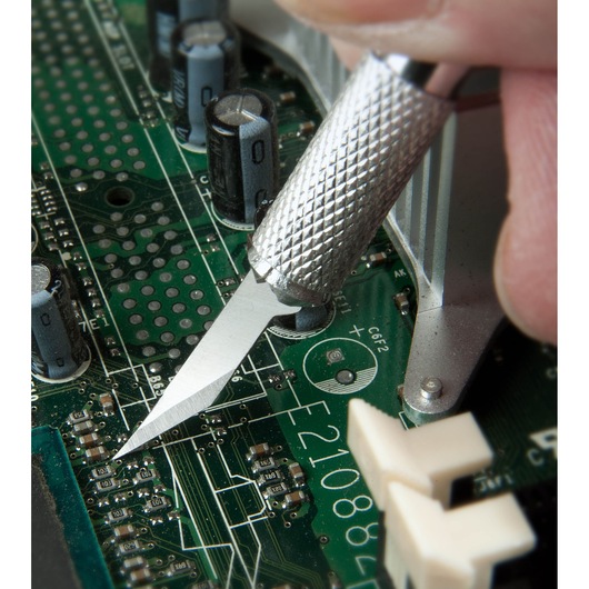 STANLEY STHT0-73872 precision knife cutting on a green circuit board, close-up photo.