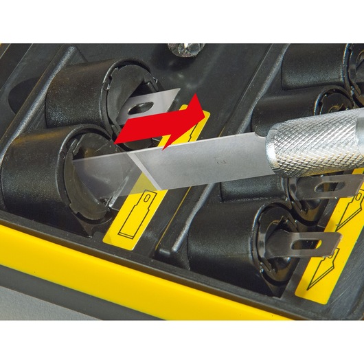 STANLEY STHT0-73872 utility knife blade being inserted into black storage case with yellow label, close-up photography.