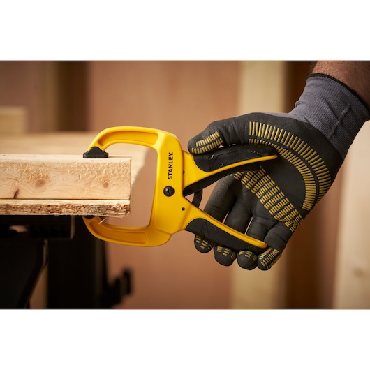 STANLEY STHT0-83199 yellow clamp being used to secure wood, close-up side view.