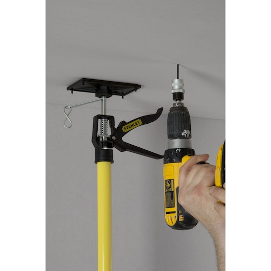 STANLEY STHT1-05932 adjustable drywall support pole in use during ceiling installation.