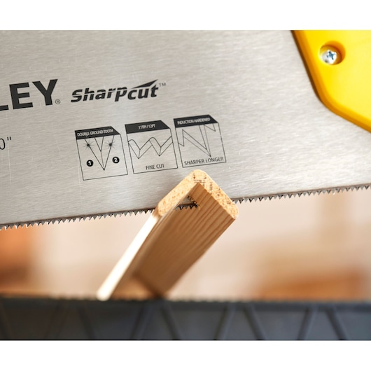 STANLEY STHT20372-1 hand saw blade close-up cutting wood, SharpCut teeth and yellow handle visible.