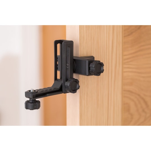 STANLEY STHT77499-1 photography door clamp mount in black attached to a wooden door, side angle.