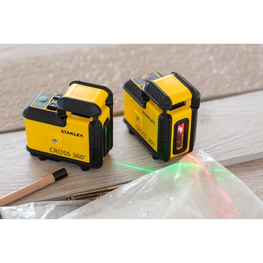 Photo of STANLEY STHT77504-1 CROSS 360 laser level, two units, on wooden surface with green and red laser lines.